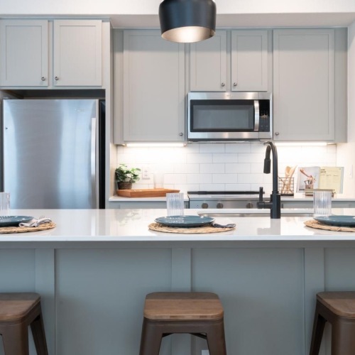 a kitchen with a bar stools and a table
